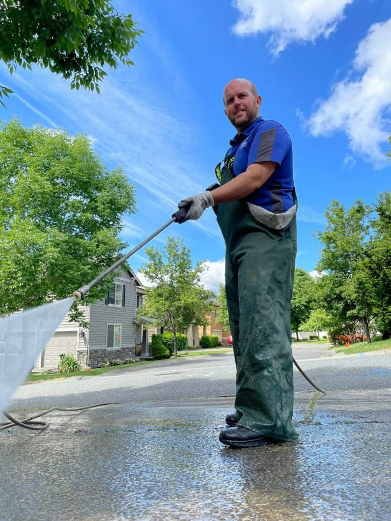 a-man-is-cleaning-the-street-with-a-hose-dyymrjyxe84