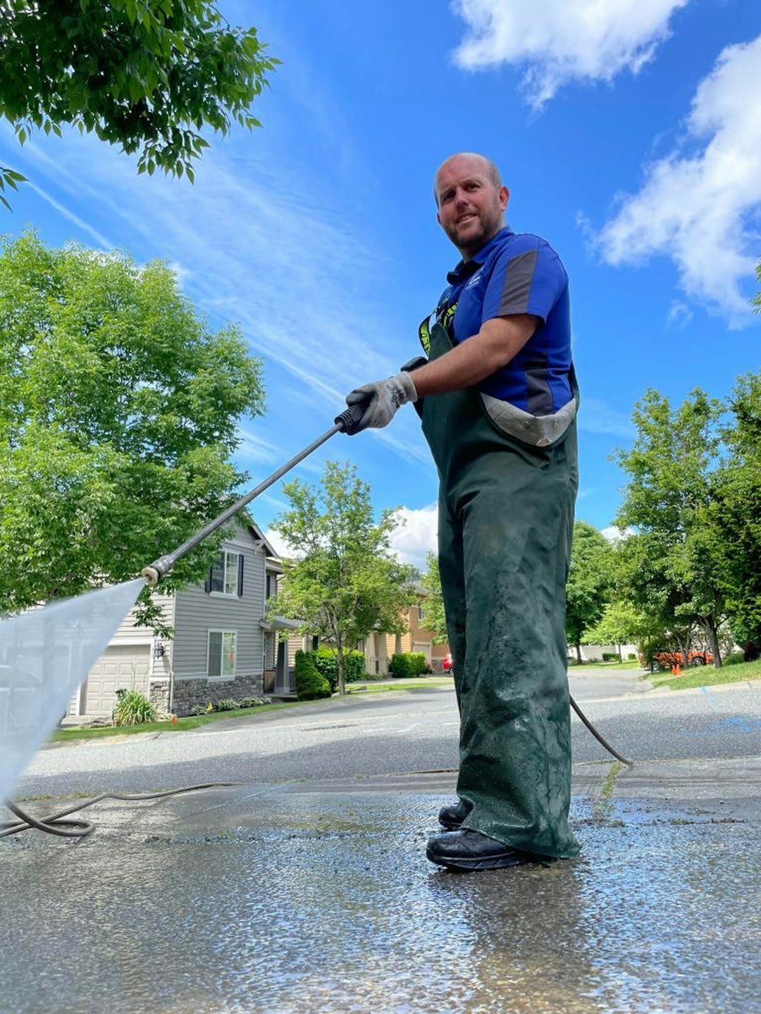 a-man-is-cleaning-the-street-with-a-hose-dyymrjyxe84