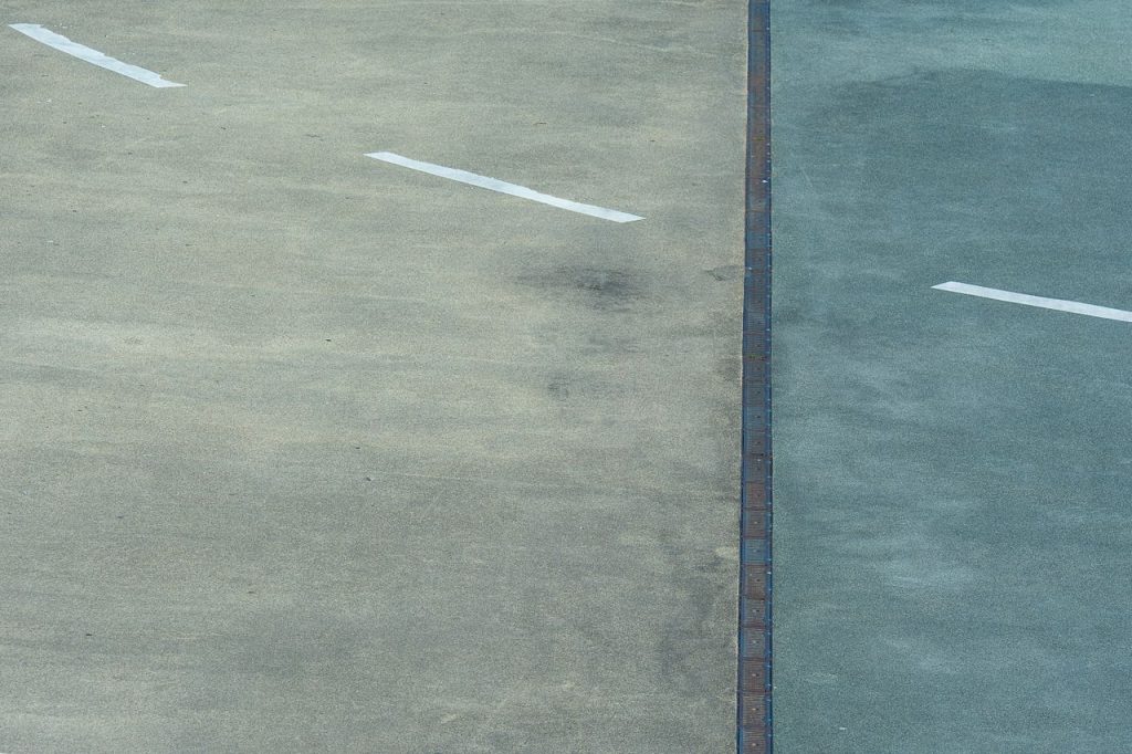 Textured asphalt with white lines in Rotterdam, a minimalist cityscape view.